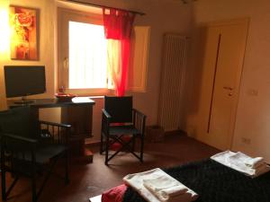 Pokój z biurkiem, krzesłami i oknem w obiekcie San Martin del Colle Holiday Home w mieście Casciana Terme