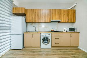 a kitchen with a washing machine and a refrigerator at Sabah Residance Garden Wiev in Baku