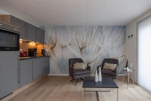 FACT Apartments في أرنولدشتاين: غرفة معيشة مع كرسيين ومطبخ