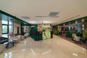 una hall con divani e sedie e un uomo di Dostyk Business Hotel ad Aqtau