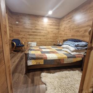 a bedroom with a bed with wooden walls and a rug at Домик с сауной для отдыха in Katase