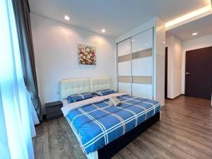 - une chambre avec un grand lit et une couverture bleue dans l'établissement Jeff and Ricky Homestay 73@Vivacity Megamall, à Kampong Tabuan