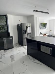 a kitchen with a black counter and a refrigerator at hermosa casa nueva in Copacabana