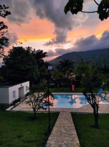a swimming pool with a sunset in the background at hermosa casa nueva in Copacabana