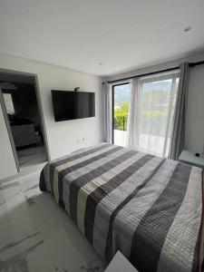 a bedroom with a bed and a large window at hermosa casa nueva in Copacabana