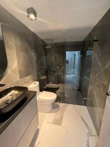 een badkamer met een toilet, een wastafel en een douche bij hermosa casa nueva in Copacabana