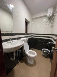 a bathroom with a toilet and a sink at Hotel Sai Advika in Mapusa