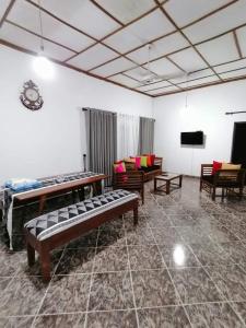 Pokój z kanapami i krzesłami oraz telewizorem z płaskim ekranem w obiekcie Kingsland Hostel w mieście Anuradhapura
