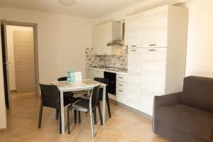 a kitchen and dining room with a table and chairs at MARIS Apartments & Bedrooms in Alghero
