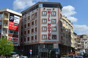 un edificio alto con un cartel de hotel en una ciudad en Nil Hotel, en Gaziantep