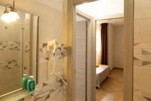 a bathroom with a phone on a wall next to a mirror at MARIS Apartments & Bedrooms in Alghero