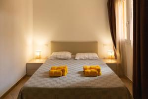a bedroom with a bed with two yellow pillows at MARIS Apartments & Bedrooms in Alghero