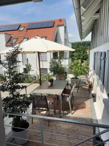 um pátio com uma mesa e guarda-sol numa varanda em kleines Landhaus Bodensee em Überlingen