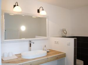 ein Bad mit einem Waschbecken und einem Spiegel in der Unterkunft kleines Landhaus Bodensee in Überlingen