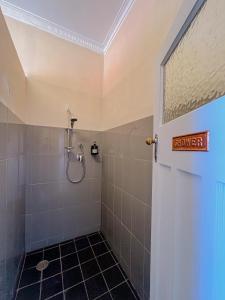 a bathroom with a shower with a sign on the door at Commercial Hotel Bega in Bega