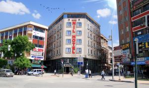 a building on a city street with people crossing the street at Nil Hotel in Gaziantep