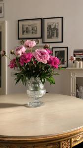 un jarrón lleno de flores rosas en una mesa en Bohemian House, en Milán