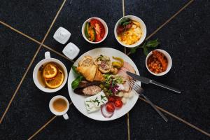 un plato de comida en una mesa con tazones de comida en Leonardo Boutique Hotel Krakow City Center, en Cracovia