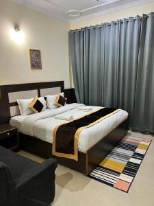 1 dormitorio con 1 cama y una ventana con cortinas en Sky Pie hotel, en Dharamshala