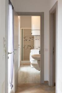 a bathroom with a white toilet and a sink at MARIS Apartments & Bedrooms in Alghero