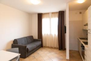 a living room with a couch and a window at MARIS Apartments & Bedrooms in Alghero
