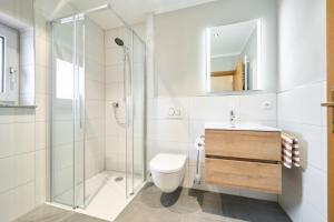 een badkamer met een douche, een toilet en een wastafel bij Wirt z´Uttlau Familienhotel Höng in Haarbach