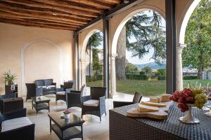 an outdoor patio with tables and chairs and windows at Villa Premoli - Dimora storica del XVII secolo in Cavaso del Tomba