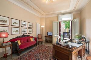 sala de estar con sofá rojo y escritorio en Villa Premoli - Agriturismo di charme en Cavaso del Tomba