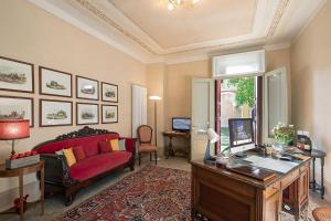 a living room with a red couch and a desk at Villa Premoli - Agriturismo di charme in Cavaso del Tomba