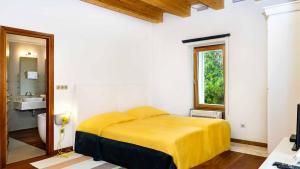 a bedroom with a yellow bed and a sink at A beachfront villa near Omiš with a sauna and a gym in Lokva Rogoznica