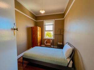 a small bedroom with a bed and a window at Commercial Hotel Bega in Bega