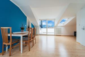 a dining room with blue walls and a table and chairs at Mias Apartments - #MiasEppan#Badl in Appiano sulla Strada del Vino