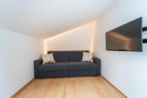 a living room with a couch and a flat screen tv at Mias Apartments - #MiasEppan#Badl in Appiano sulla Strada del Vino