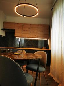 a kitchen with a table and chairs and aendant light at Akacjowy Apartament in Sianozety