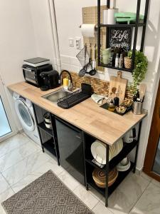 a kitchen counter with a desk and a microwave at Vis-a-Vis Studio - Gara de Nord in Bucharest