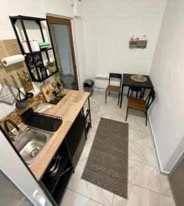a small kitchen with a sink and a table at Vis-a-Vis Studio - Gara de Nord in Bucharest