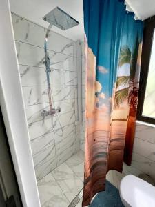a bathroom with a shower with a mural of a beach at Vis-a-Vis Studio - Gara de Nord in Bucharest