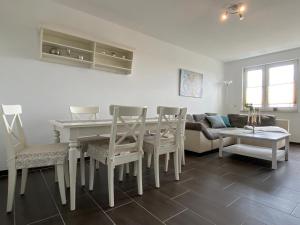 a living room with a table and chairs and a couch at Gästewohnung KL. WZL 29_7 in Klein Wanzleben