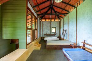 a bedroom with two beds in a room with green walls at The Woods in Haputale