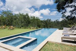 - une piscine avec des chaises longues à côté d'une cour dans l'établissement Stafford Bungalow, à Nuwara Eliya