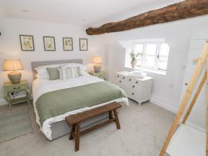 a bedroom with a bed and two lamps and a window at Ashton House in Moreton in Marsh