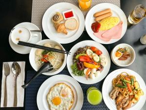 una mesa con platos blancos de comida. en Hotel Clover Asoke - SHA Extra Plus, en Bangkok
