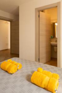 a group of yellow towels sitting on a bed at MARIS Apartments & Bedrooms in Alghero