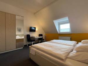 1 dormitorio con cama, escritorio y ventana en Hotel Kaufhold - Haus der Handweberei, en Waltrop