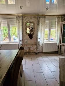 a dining room with a table and some windows at Maison charmante à Berlaimont avec jardin et parking inclus in Berlaimont