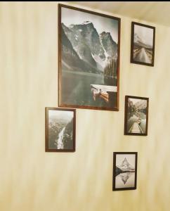 una pared con cuatro cuadros en una pared en Chambres d'hôtes Chez Valérie, en Arette