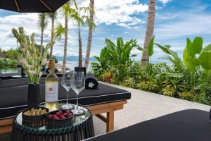 una mesa con una botella de vino y copas en Villa Sea View Beach Estate, en Buleleng
