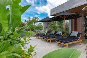 una fila de sillones y una sombrilla en Villa Sea View Beach Estate, en Buleleng