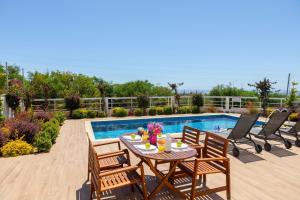 um pátio com uma mesa e cadeiras ao lado de uma piscina em Napa Bay View Villa 3 em Agia Napa