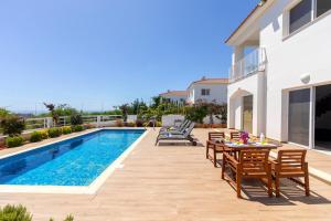 a patio with a table and chairs next to a swimming pool at Napa Bay View Villa 3 in Ayia Napa
